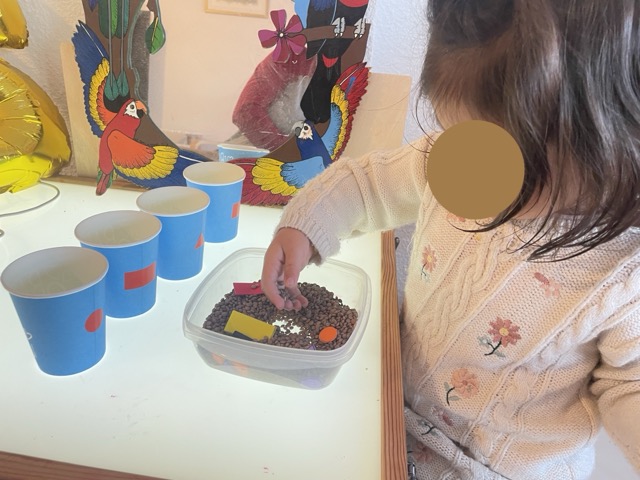 Una niña jugando con formas y ordenando en vasos